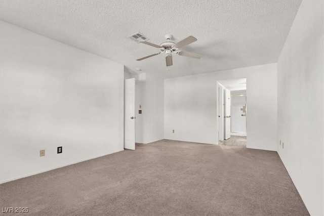 carpeted empty room with ceiling fan and a textured ceiling