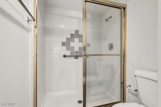 bathroom with toilet and an enclosed shower