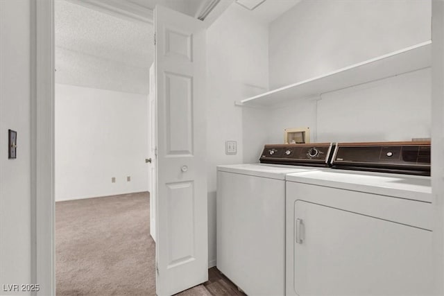 laundry area featuring washing machine and clothes dryer and light colored carpet