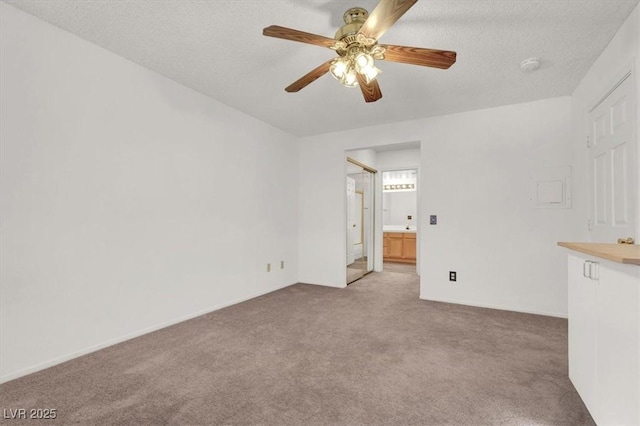 carpeted spare room with ceiling fan and a textured ceiling