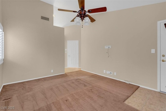 carpeted empty room with ceiling fan and high vaulted ceiling