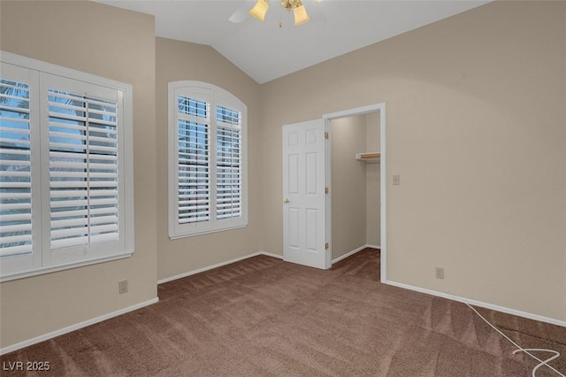 empty room with vaulted ceiling, carpet flooring, and ceiling fan