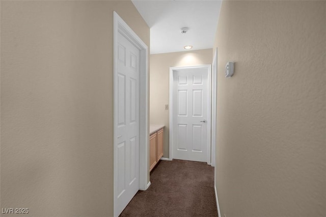 hallway featuring dark carpet