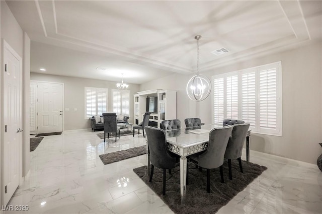 dining room with an inviting chandelier and a tray ceiling