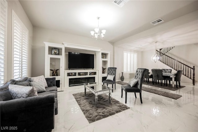 living room featuring built in features and a chandelier