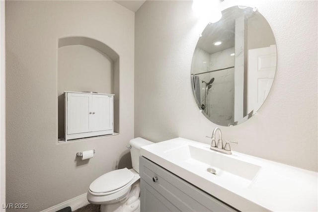 bathroom with a shower, vanity, and toilet