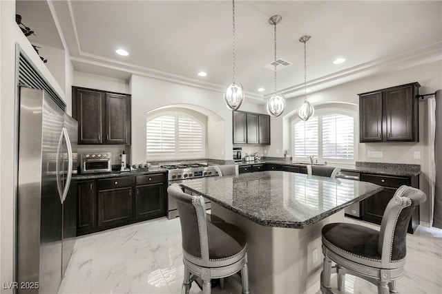 kitchen with dark brown cabinetry, a kitchen island, a kitchen breakfast bar, and appliances with stainless steel finishes