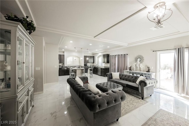 living room with crown molding and a chandelier