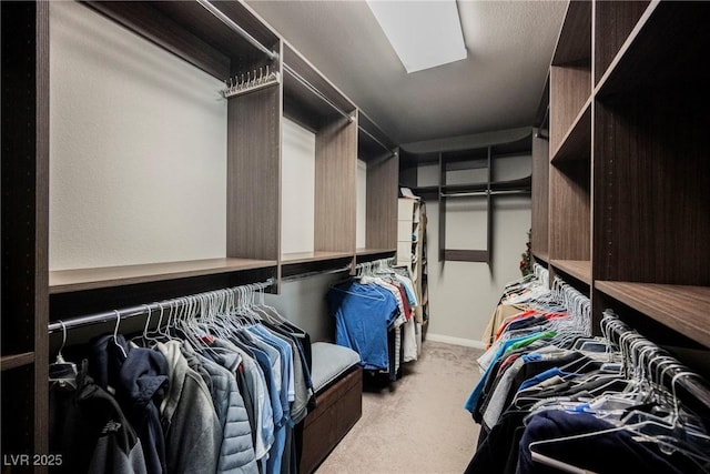 walk in closet featuring light colored carpet and a skylight