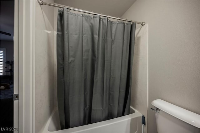 bathroom featuring shower / bath combination with curtain, lofted ceiling, and toilet