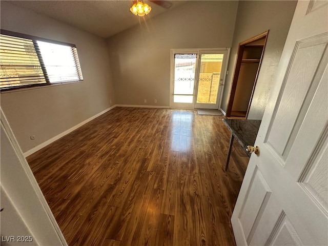 unfurnished bedroom featuring dark wood-type flooring and lofted ceiling