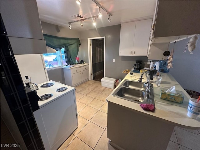 kitchen with white cabinets, sink, light tile patterned floors, and electric range