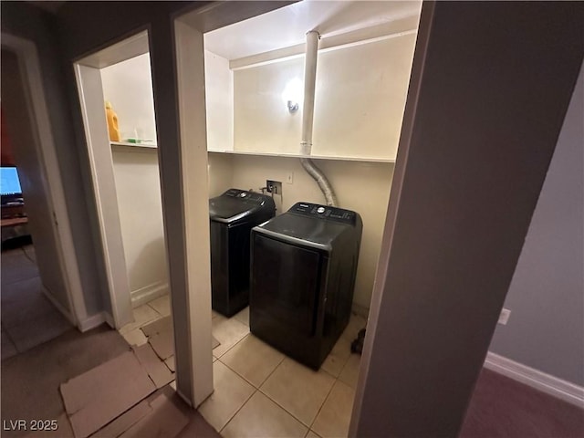 laundry area with cabinets, washing machine and clothes dryer, and light tile patterned floors