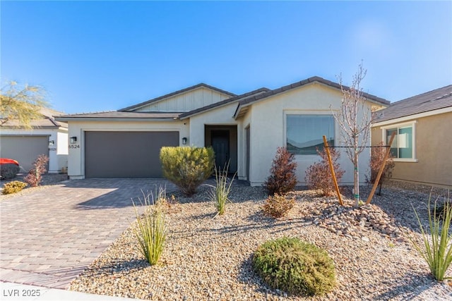 single story home with a garage, decorative driveway, and stucco siding