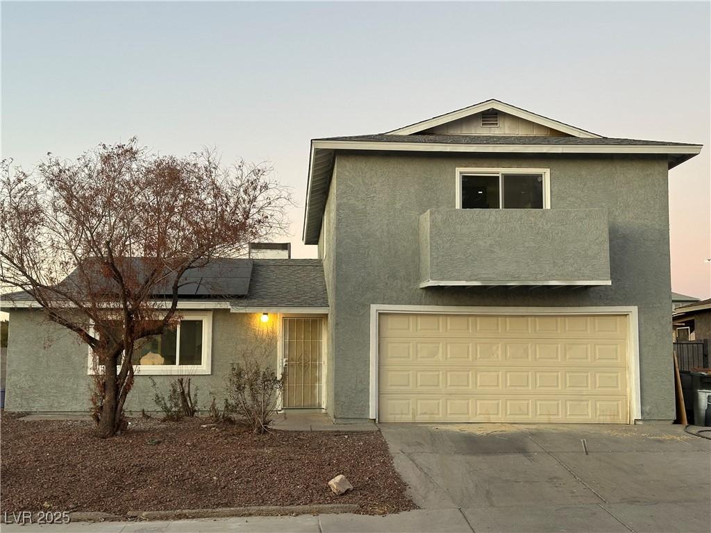 view of front property with a garage and solar panels