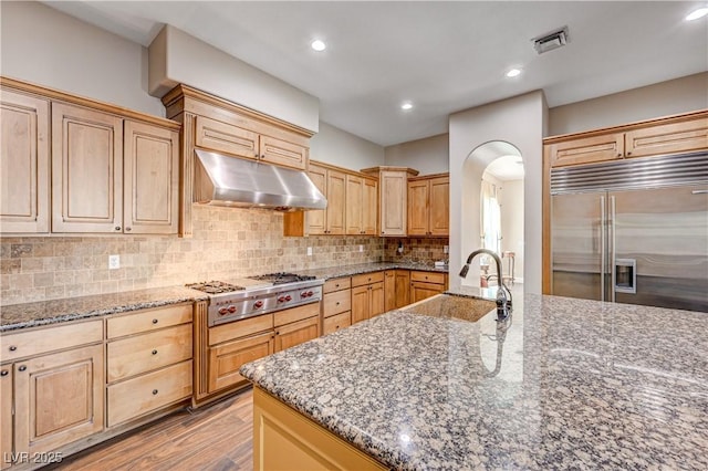 kitchen with appliances with stainless steel finishes, sink, and dark stone counters