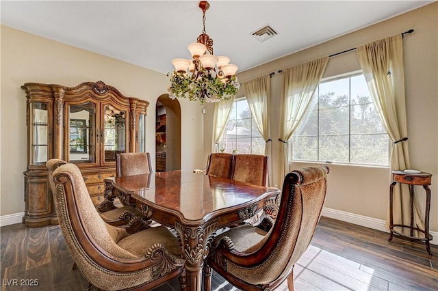 dining area with an inviting chandelier and dark wood-type flooring