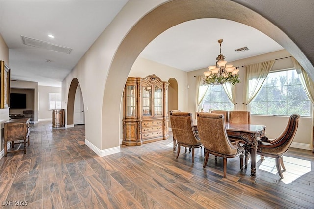 dining area featuring dark wood-type flooring and a chandelier