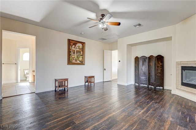 unfurnished living room featuring ceiling fan, dark hardwood / wood-style floors, and a fireplace