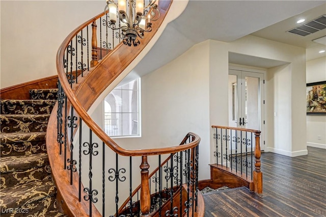 stairway featuring hardwood / wood-style flooring and a chandelier