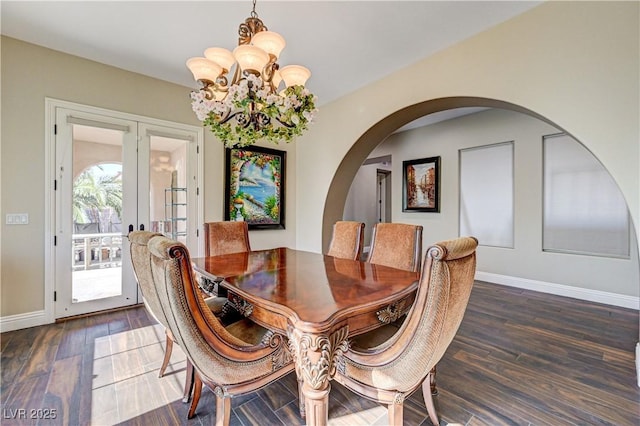 dining room featuring an inviting chandelier, dark wood-type flooring, and french doors