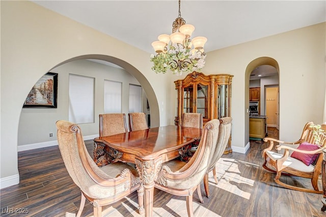 dining room with dark wood-type flooring and a chandelier