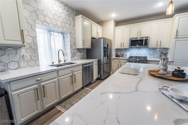 kitchen featuring light stone counters, sink, white cabinetry, and stainless steel appliances