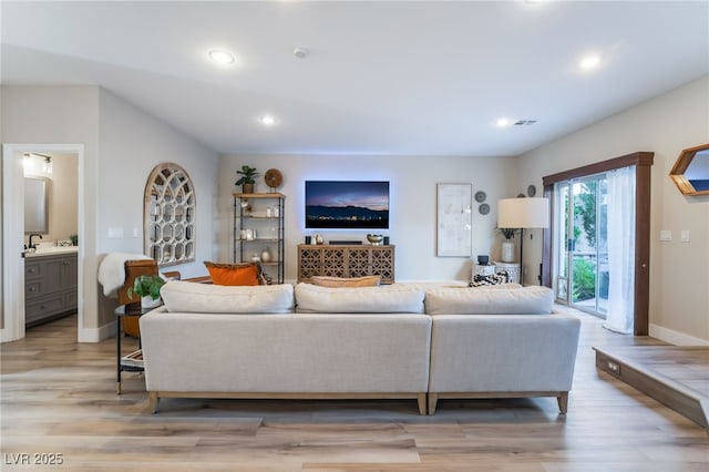 living room with sink and light hardwood / wood-style floors