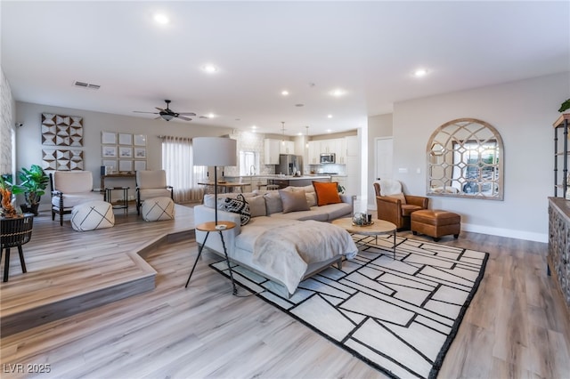 living room featuring ceiling fan and light wood-type flooring