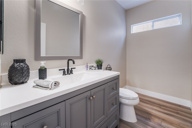 bathroom featuring vanity, toilet, and hardwood / wood-style floors