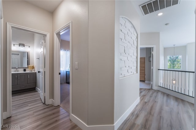 hall featuring sink and light wood-type flooring