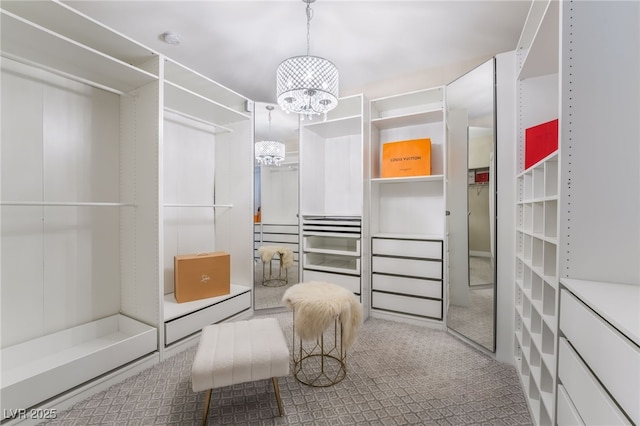 walk in closet with a notable chandelier