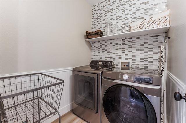 laundry area with light hardwood / wood-style flooring and washing machine and dryer