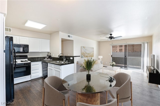 kitchen featuring dark wood-type flooring, sink, black appliances, ceiling fan, and white cabinets