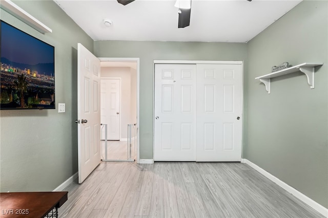 unfurnished bedroom with light hardwood / wood-style flooring, ceiling fan, and a closet