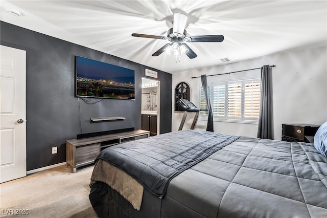 bedroom featuring ensuite bathroom, carpet floors, and ceiling fan