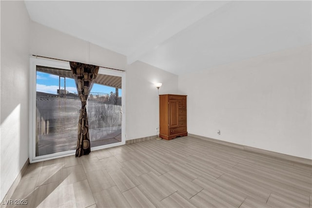 unfurnished living room featuring lofted ceiling with beams