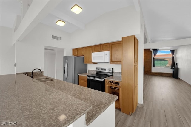 kitchen featuring sink, light hardwood / wood-style flooring, appliances with stainless steel finishes, beam ceiling, and kitchen peninsula