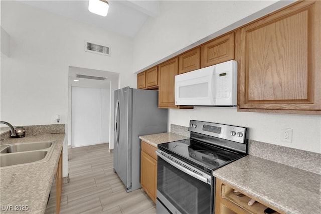 kitchen with appliances with stainless steel finishes, sink, high vaulted ceiling, and beam ceiling