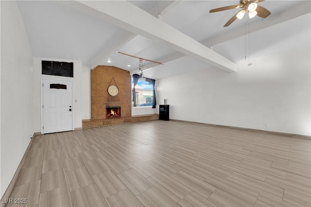 unfurnished living room with a brick fireplace, vaulted ceiling with beams, and ceiling fan