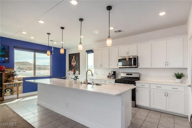 kitchen featuring white cabinetry, sink, light tile patterned flooring, and appliances with stainless steel finishes