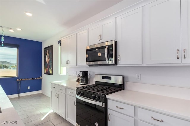 kitchen featuring stainless steel appliances, light tile patterned floors, and white cabinets