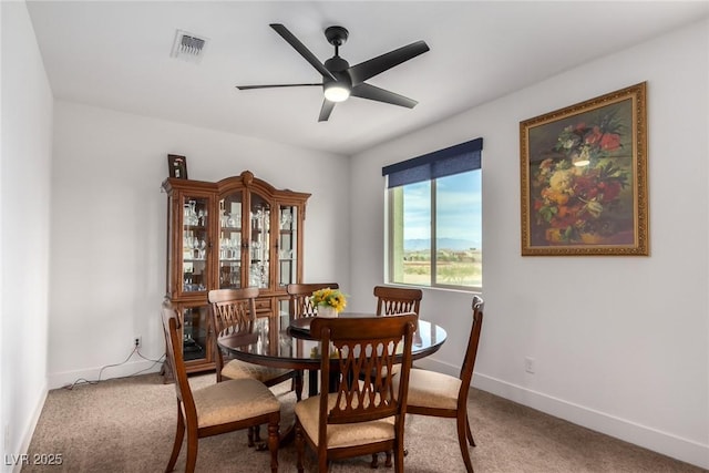 carpeted dining space with ceiling fan