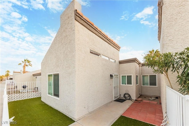 rear view of property featuring a patio and a lawn