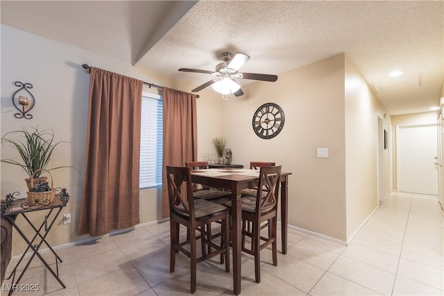 tiled dining space with ceiling fan and a textured ceiling