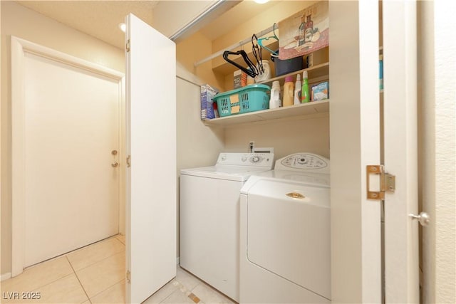 laundry room featuring washing machine and dryer and light tile patterned flooring