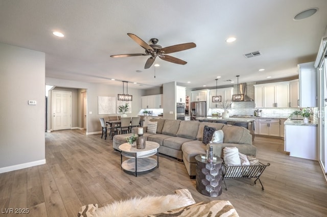 living room featuring ceiling fan and light wood-type flooring