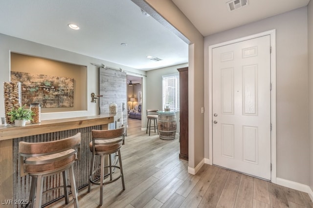 bar with light hardwood / wood-style floors