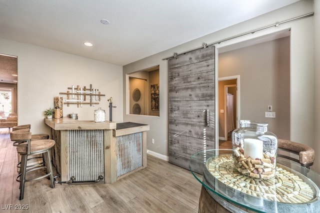 bar featuring a barn door, radiator, butcher block countertops, and light wood-type flooring