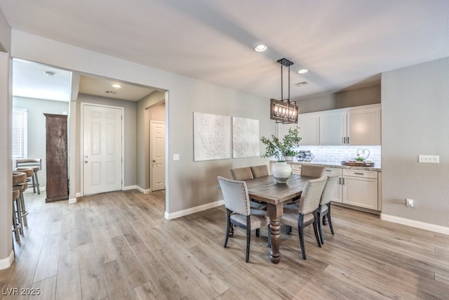 dining space featuring a notable chandelier and light hardwood / wood-style floors